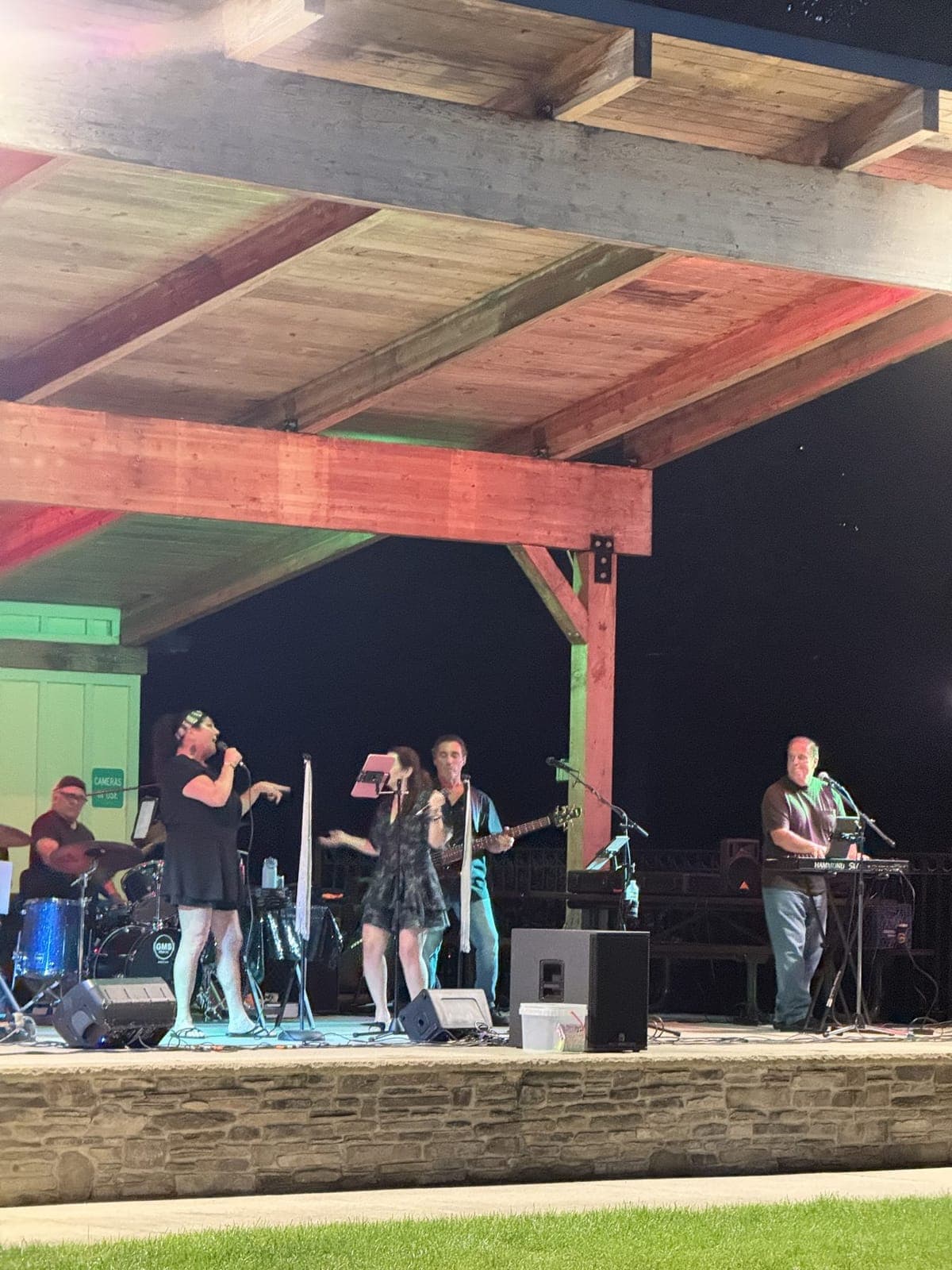 The full band on stage, including vocals, guitar, keyboard and drums, playing hits spanning the 1960s to today.